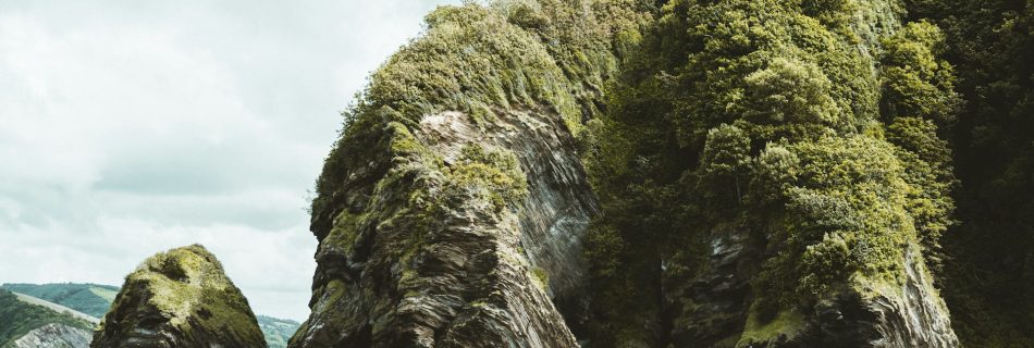 green-and-gray-rock-formation-on-body-of-water