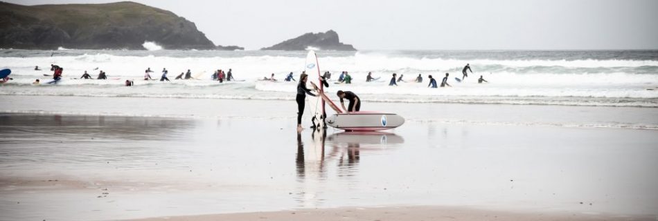 surfers in cornwall beach