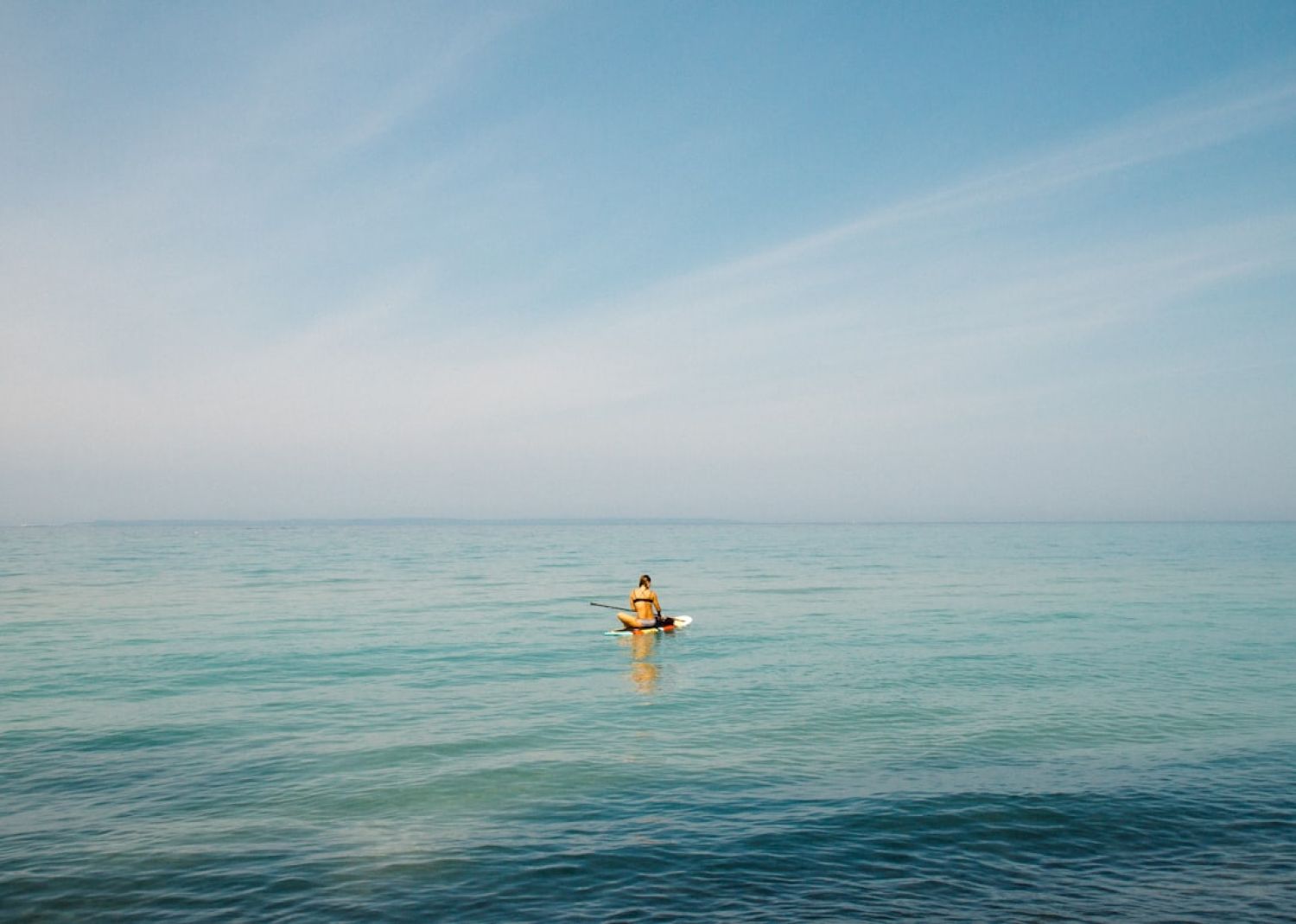 Paddleboard - person in middle of body of water during daytime