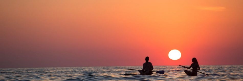 Paddleboard - Man and Woman Boat Rowing in Sea during Golden Hour