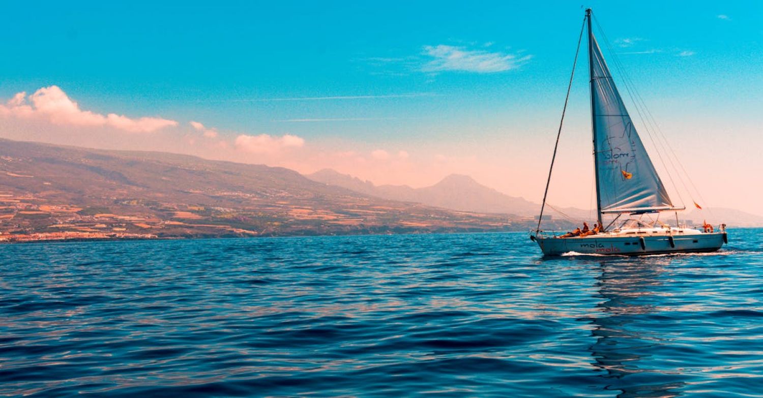 Sailing - Sailboat Sailing on Water Near Island