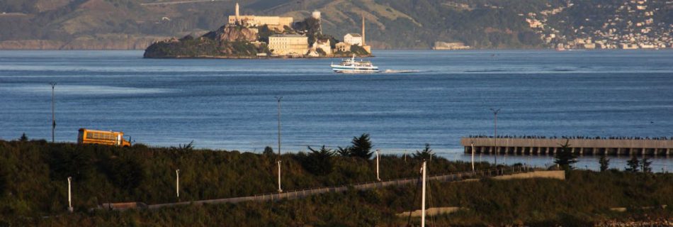 Sailing Routes - A sailboat is docked in the water near a large island