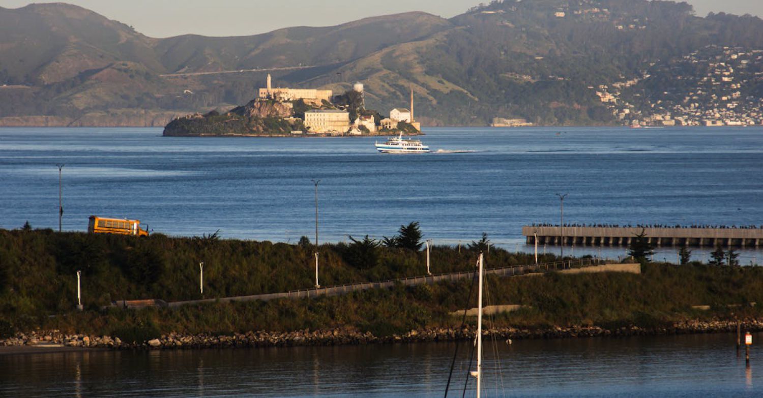 Sailing Routes - A sailboat is docked in the water near a large island