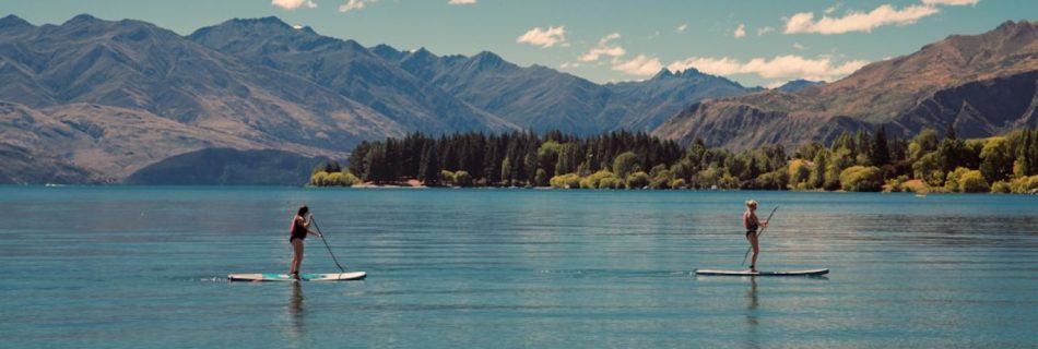 Paddleboarding - two person riding on paddle boards during daytime